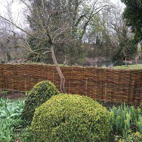 Woven willow fence bordering a moat